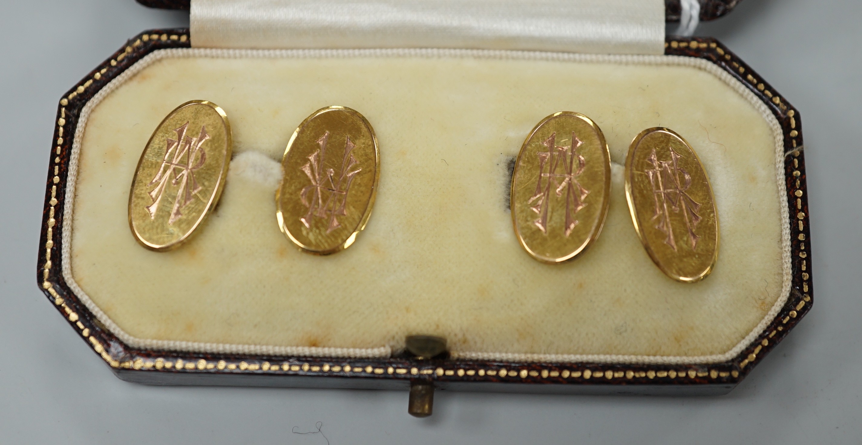 A pair of George V 9ct. gold oval cuff links, with engraved monograms, cased, 4.3 grams.